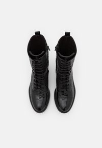 Botines de cuero negro con textura de cocodrilo, cordones en la parte delantera, cremallera lateral y diseño de punta redondeada.