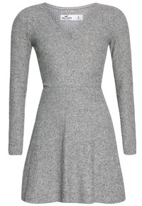 Robe grise à manches longues avec un corsage ajusté, une jupe évasée et une texture côtelée. Décolleté en V et étiquette de la marque au dos. Taille petite.