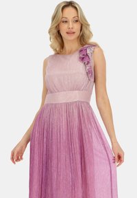 Fioletowa sukienka wieczorowa w gradientzie z dopasowanym gorsetem, plisowanym dołem i falbaną na ramieniu. Wykonana z połyskującej, teksturowanej tkaniny.