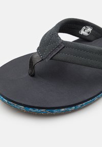 Infradito neri con supporto testurizzato, cinturino in morbido tessuto e accento blu sulla suola. Caratterizzati da un'etichetta con logo prominente sul cinturino.