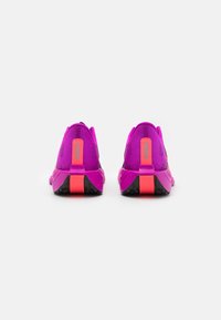 Lilla sportssko med en åndbar mesh-overdel, kontrasterende pink detaljer og en sort tekstureret sål. Bemærkelsesværdigt hælkapsele-design.