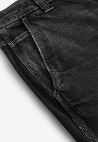 Zwarte denim jeans met een vervaagde textuur, voorzien van witte stiksels, een standaard vijf-pocket ontwerp en een middelhoge tailleband.