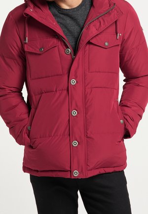 Veste rembourrée rouge avec capuche, dotée d'une fermeture éclair à l'avant, de boutons-pression, de deux poches poitrine et d'une texture matelassée. Assortie à une chemise grise.