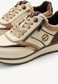 Sneakers beige con accenti marroni, caratterizzati da una tomaia in pelle e suede testurizzata, lacci rotondi e un dettaglio con zip laterale.