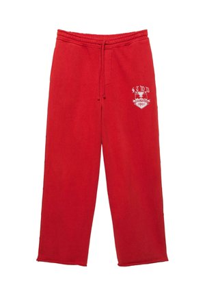 Červené tepláky s elastickým pásom a šnúrkou, s bielou grafikou a textom "STWD 1991" na ľavom stehne.