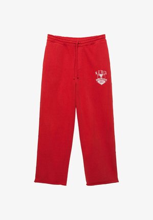 Červené tepláky s elastickým pásom a šnúrkou, s bielou grafikou a textom "STWD 1991" na ľavom stehne.