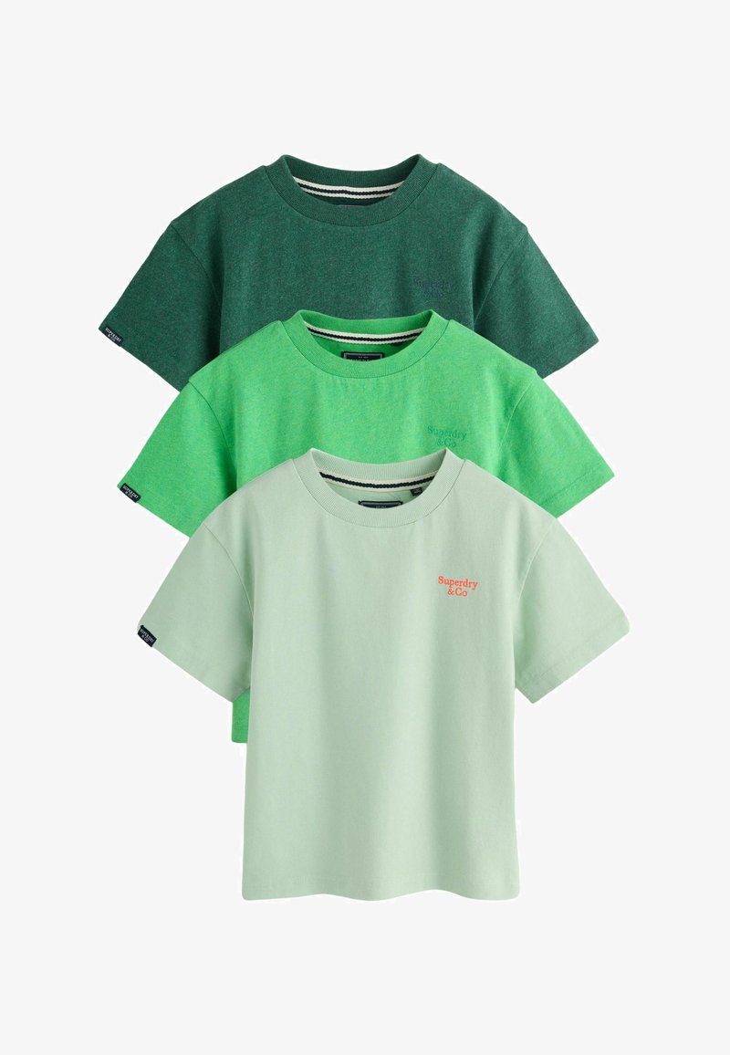 Trois t-shirts à manches courtes pliés en vert foncé, vert vif et vert pâle, chacun avec un col rond et un petit logo sur la poitrine et la manche.
