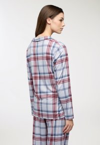 Set di pigiama a maniche lunghe a quadri nei toni del blu, rosso e grigio. Tessuto in cotone morbido, vestibilità comoda, con colletto abbottonato e pantaloni coordinati.