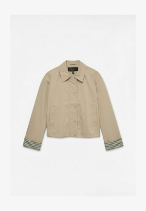 Beige kort jakke med trykknapper, spids krave, forlommer og ternet mønster indeni ærmekanterne.