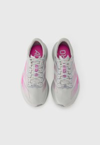 Szürke sportcipők rózsaszín részletekkel, texturált felsőrésszel, fehér fűzőkkel és párnázott talppal, az "ADIZERO" felirattal a talpbéléseken.