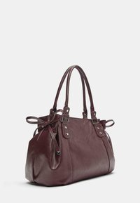 Bordowa torebka z ekologicznej skóry z dwoma uchwytami, o zaokrąglonym kształcie, marszczonymi bokami, srebrnymi elementami i kokardkami na uchwytach.