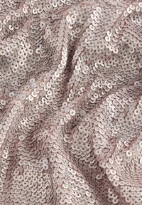Tissu à sequins rose clair présentant des sequins circulaires disposés de manière rapprochée dans un motif texturé en vagues, réfléchissant la lumière à la surface.