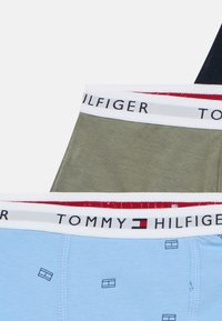 Boxershorts i blått, olivgrönt och svart bomull, med elastiska midjeband prydda med "TOMMY HILFIGER"-logotypen och geometriska mönster på det blå paret.