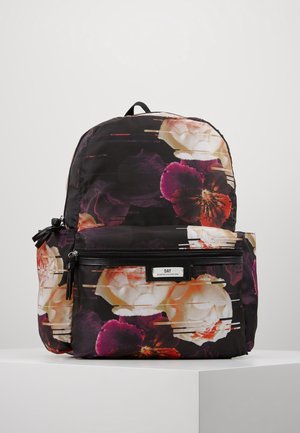 Sac à dos noir avec grand imprimé floral blanc, violet et orange, poche avant zippée et étiquette "DAY" sur une surface blanche et minimaliste.