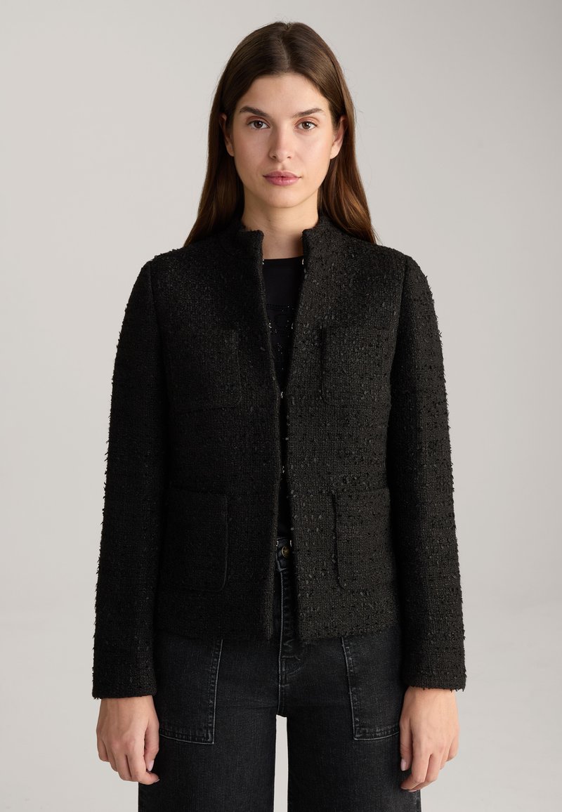 Zwarte textuur blazer met een licht gestructureerde pasvorm, voorzien van een ronde halslijn, zonder knopen en twee voorzakken.