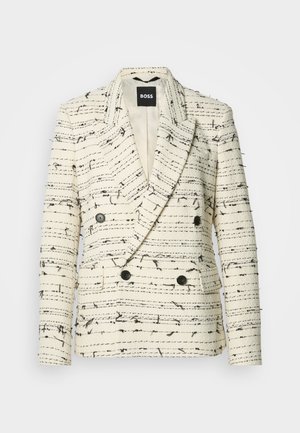 Blazer doppiopetto in tessuto testurizzato crema e nero, con colletto a scollo, tasche frontali e bottoni neri.