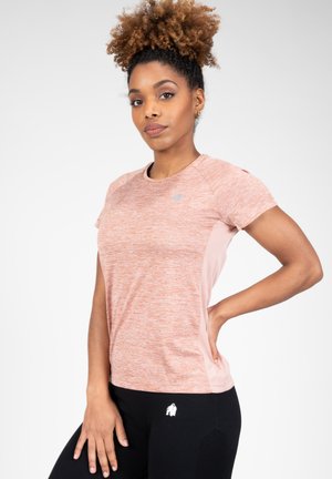 Korte mouwen sportshirt in een gemêleerd lichtoranje met textuurstof en zijpanelen van mesh. Gecombineerd met zwarte leggings met accenten.