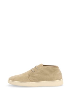 Zapato casual beige de ante de caña media con dos ojetes para cordones, puntera redondeada y suela plana de goma color crema.