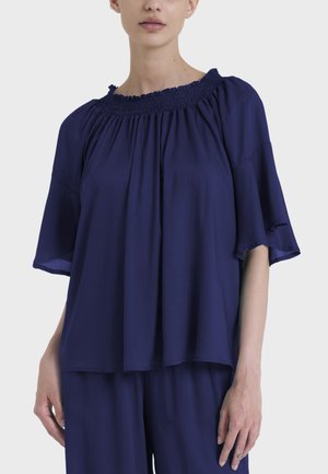 Blusa blu navy con scollatura arricciata, maniche a farfalla corte e vestibilità morbida, realizzata in un tessuto leggero.