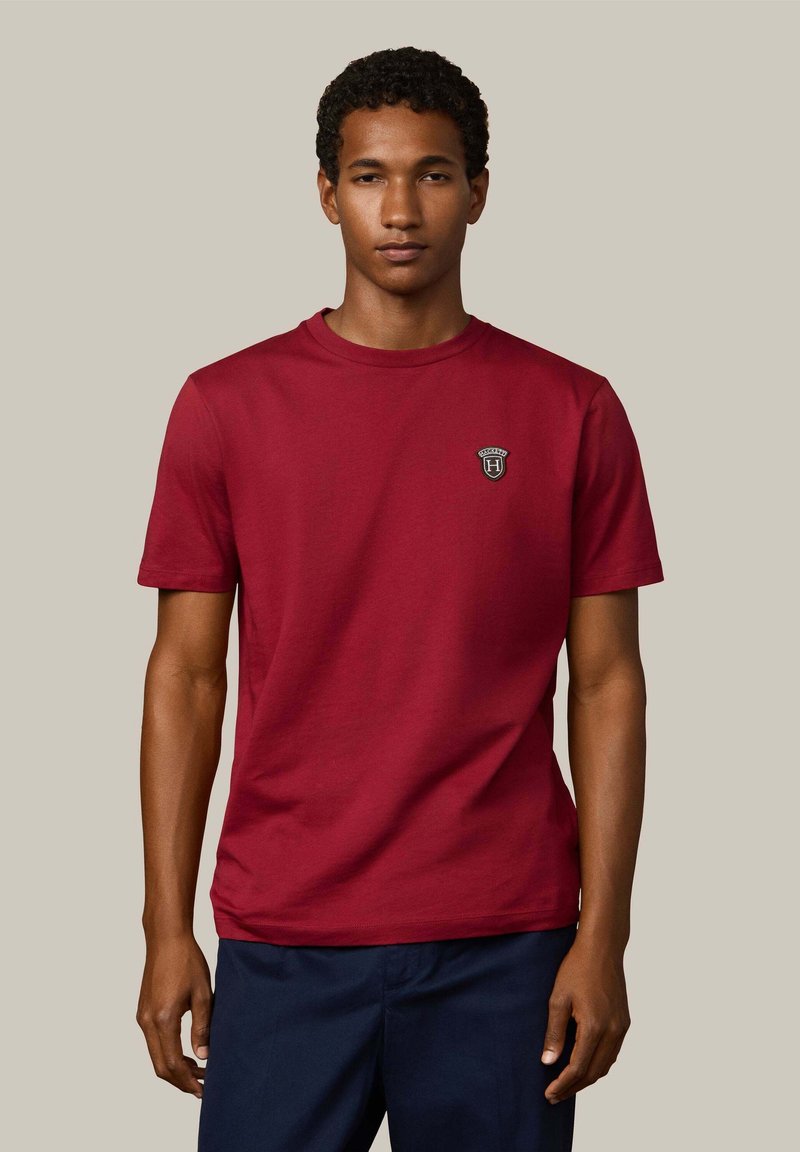 Rode katoenen t-shirt met korte mouwen, ronde hals, voorzien van een klein zwart-wit logo op de borst, gladde textuur en een relaxte pasvorm.