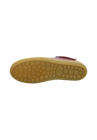 Red leather shoe with a textured, yellow rubber sole featuring circular patterns. The design includes a velcro strap for closure.