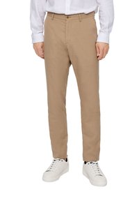 Beige trousers with a smooth texture, flat front, and a single button closure, paired with white sneakers and a white long-sleeve shirt.