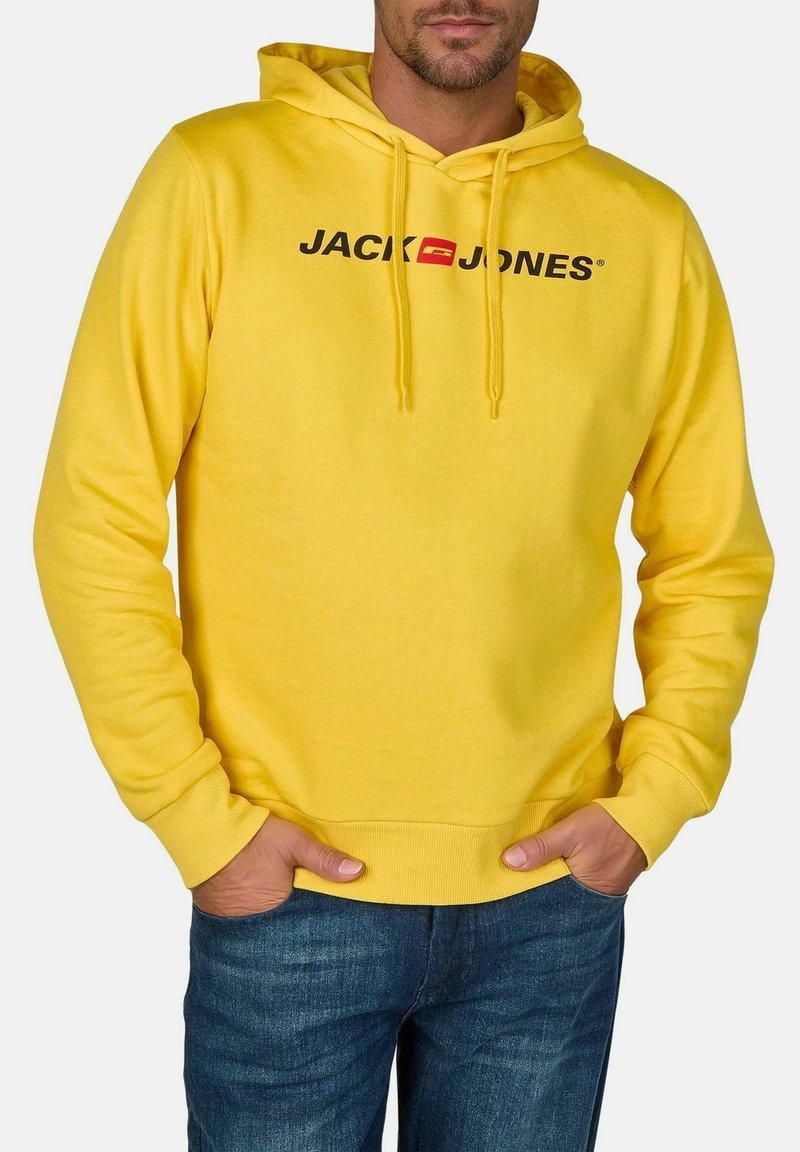 Gele hoodie van zacht materiaal met een voorkangoeroezak, trekkoorden en een bedrukt "JACK & JONES" logo in zwart en rood over de borst.