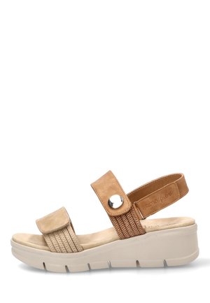 Sandalia de cuña beige con dos tiras ajustables, una con un botón, y una suela acolchada para mayor comodidad y soporte.