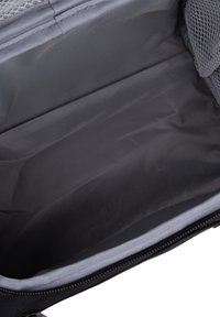 Zwart textielinterieur van een tas, met een gladde oppervlakte, een grijze voering en een netzakje aan één kant voor organisatie.