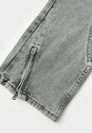 Grijze denim broek met een tapering pasvorm, voorzien van een ritssluiting zak aan de zoom en zichtbare stiksels. Glad textuur met een licht vervaagd uiterlijk.
