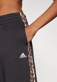 adidas Sportswear ESSENTIALS STRIPES ANIMAL PRINT 7/8 PANT - Trainingsbroek - black