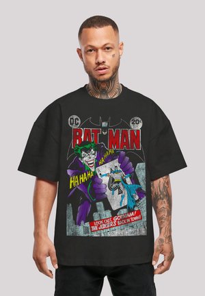Black short-sleeve t-shirt featuring colorful retro graphic print of Batman and Joker, with text and comic-style accents on front.