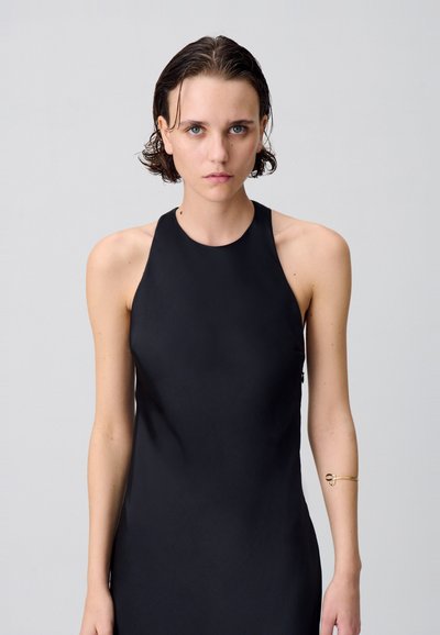 Robe noire sans manches avec un col haut et une texture lisse. Présente une fermeture éclair latérale et des accents de design minimalistes.