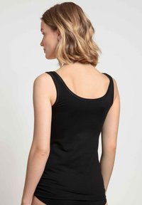 Black tank top with wide straps, a scoop back, and a fitted design, made from a smooth, stretchy fabric. No notable patterns or accents.