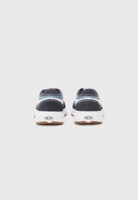 Sapatos de camurça azul-marinho com sola de borracha branca. Detalhes em azul claro e costura na parte de trás. Design de bico arredondado e plano.