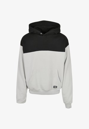 Hanorac cu glugă, cu partea superioară neagră și partea inferioară gri deschis, buzunar frontal și manșete și tiv conturate.