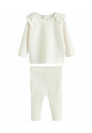 Tenue bébé en maille côtelée couleur crème avec manches longues, détails à volants aux épaules et pantalon assorti côtelé.