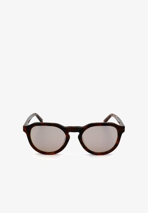 Occhiali da sole rotondi con montatura tartarugata e lenti sfumate marrone chiaro, mostrati frontalmente su uno sfondo bianco.