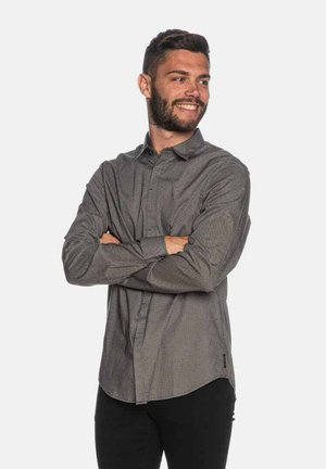 Camicia da uomo con bottoni, decorata con piccoli punti bianchi su uno sfondo scuro. Maniche lunghe, colletto classico e orlo curvo.
