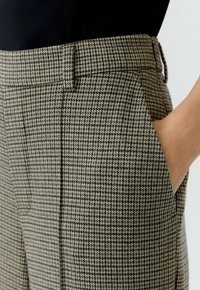 Hosen aus Wollmischung im Schachbrettmuster mit Schwarz- und Beigetönen, flacher Vorderseite, Seitentaschen und taillierter Passform.