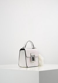 Sac à main carré avec une façade en paillettes roses scintillantes, un corps texturé blanc, des accessoires en argent et un accent en pompon duveteux. Poignée ajustable.