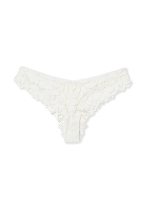 Tanga de encaje blanco con patrones florales, bordes con bordado en forma de concha y una cinturilla de tiro bajo sobre un fondo blanco liso.
