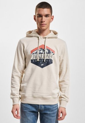 Hettegenser i beige laget av bomullsblanding med et grafisk logo i marineblått, rødt og hvitt. Har snor i hetten og ribbestrikkede mansjetter og hem.