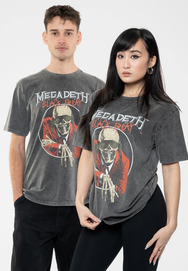 Gray cotton t-shirts featuring a skull in a red suit graphic. Loose fit, short sleeves, rounded neckline. Black pants worn with the shirts.