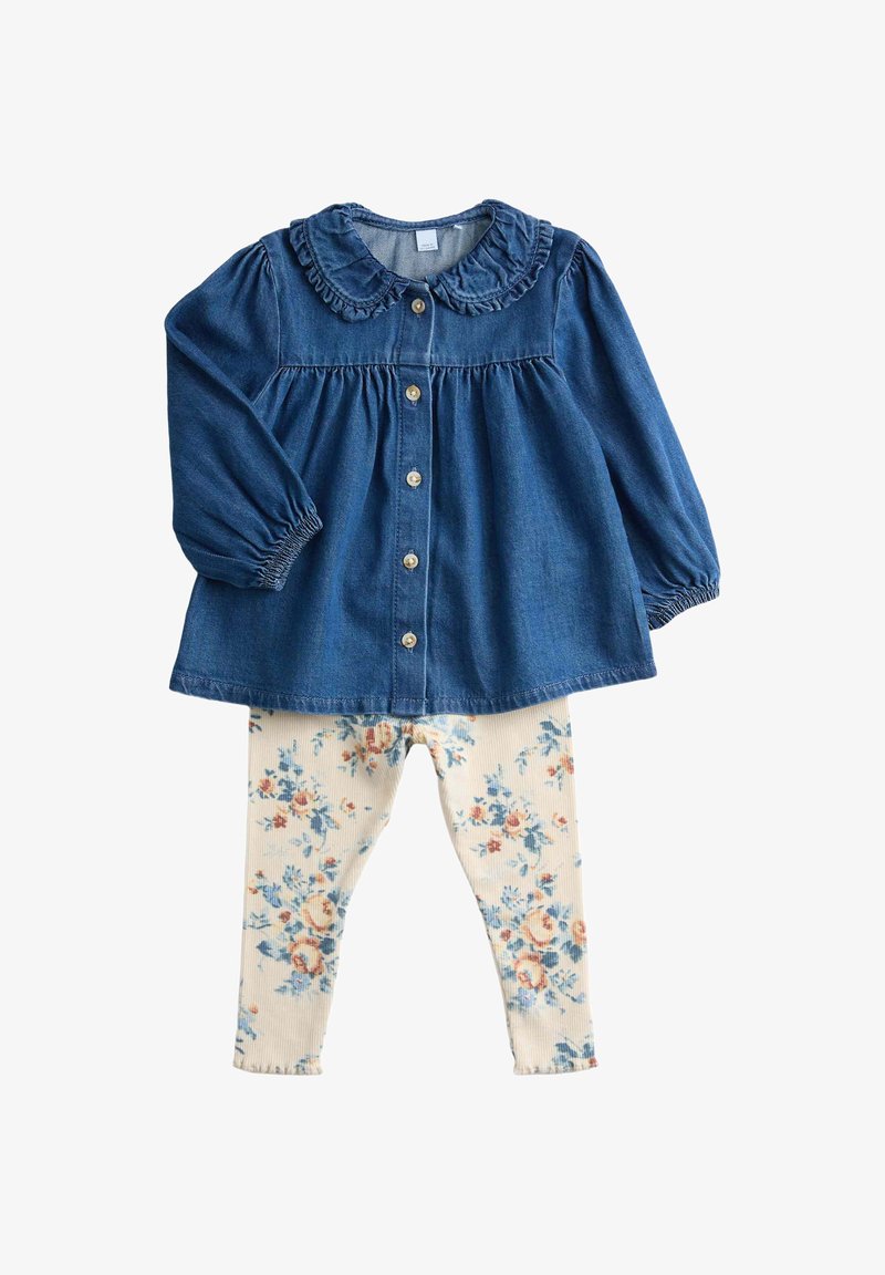 Blauw denim hemd met lange mouwen en knopen, met een gerimpelde kraag, gecombineerd met crème leggings met bloemmotief voor een kind.