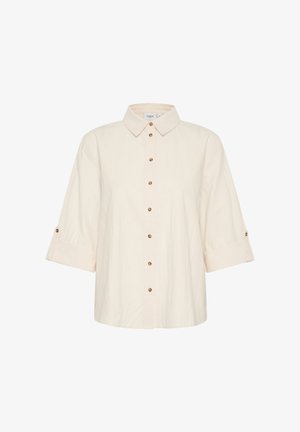 Kreemja värvi lühikeste varrukatega särk, millel on nööbid ees, krae ja rullitud varrukad. Toote omaduseks on pruunid nööbid tekstureeritud kangas.