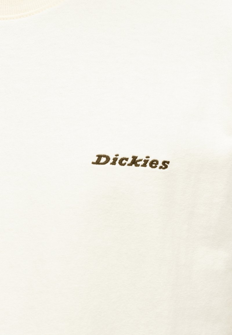 T-shirt in cotone color crema con logo "Dickies" ricamato marrone sul davanti. Girocollo, texture morbida, design minimale senza fantasie.