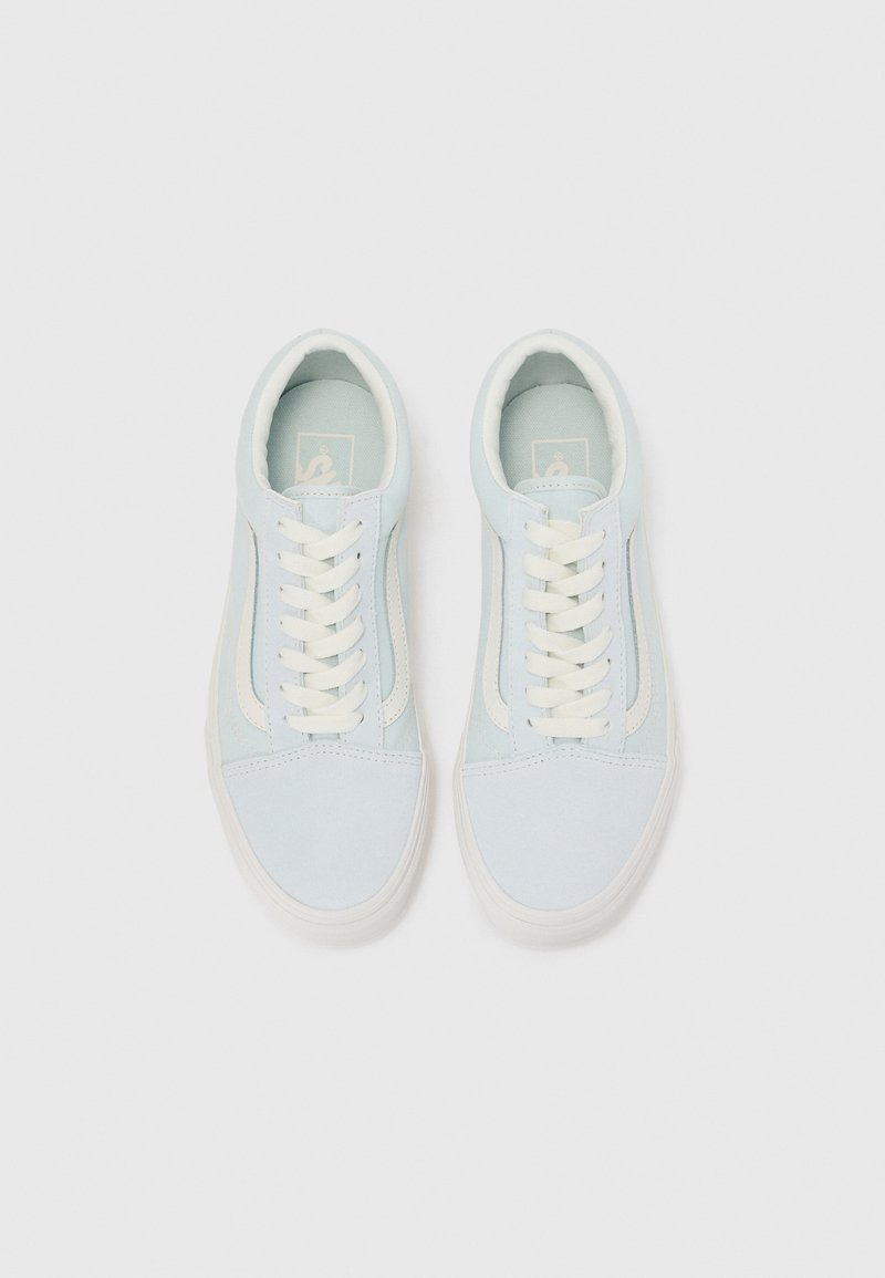 Zapatillas de ante azul claro con cordones blancos, una puntera lisa y acentos claros a lo largo de los lados. Suela plana con detalles de marca mínimos.