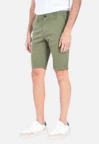 Pantaloni corti verde oliva con una vestibilità slim, realizzati in tessuto resistente, dotati di tasche frontali, chiusura con bottone sicura e orlo pulito.