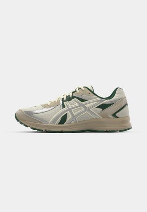 Tênis de corrida leves em creme e verde. Parte superior em malha, detalhes texturizados, sola em borracha, com bico arredondado e fecho de atacadores.